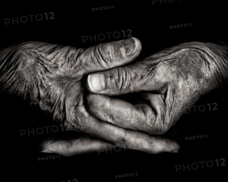 Two Wrinkled Hands against Black Background