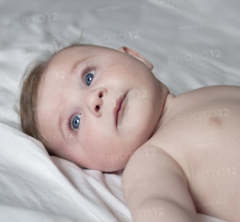 Head and Shoulders Portrait of Cute Baby Laying on Blanket