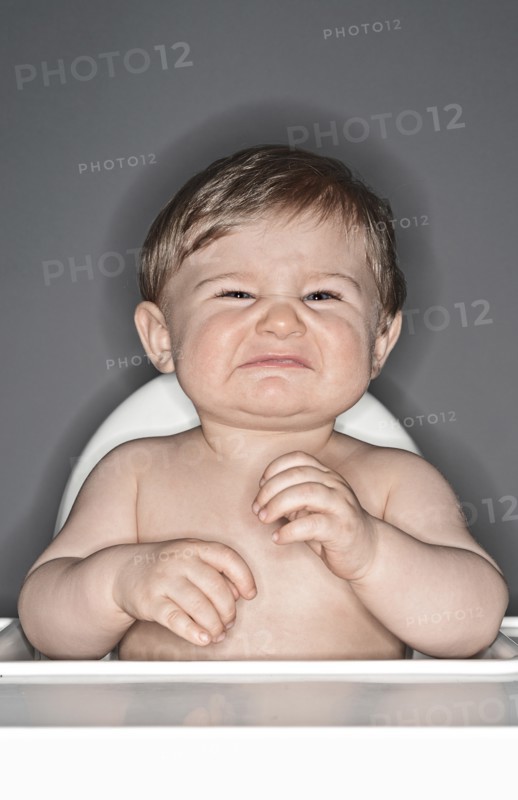 Unhappy Baby Boy in Highchair