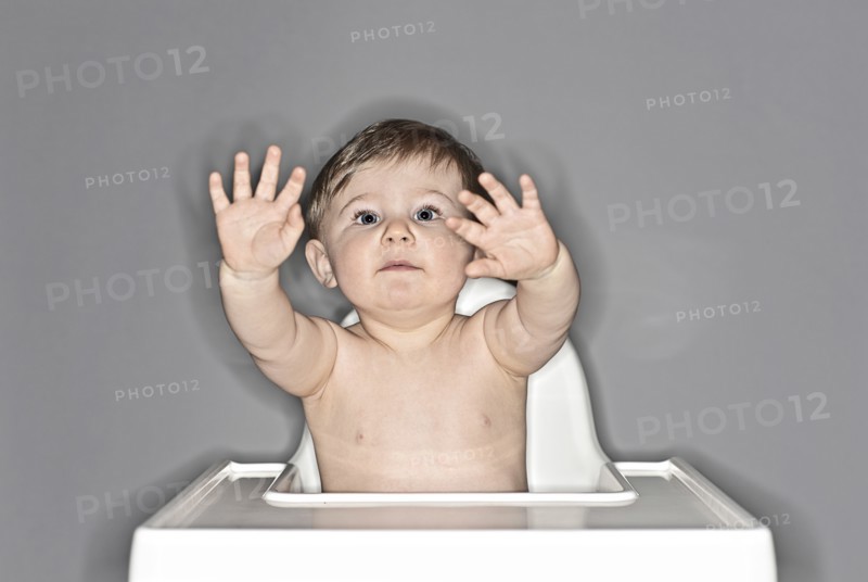 Baby Boy Sitting in Highchair and Waving