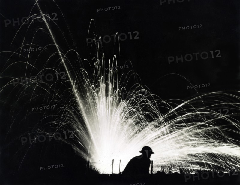 Silhouette of Soldier against Phosphorous Streamers from Bombs Exploding during Night Attack