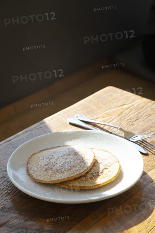 Two Pancakes with Powdered Sugar on Plate