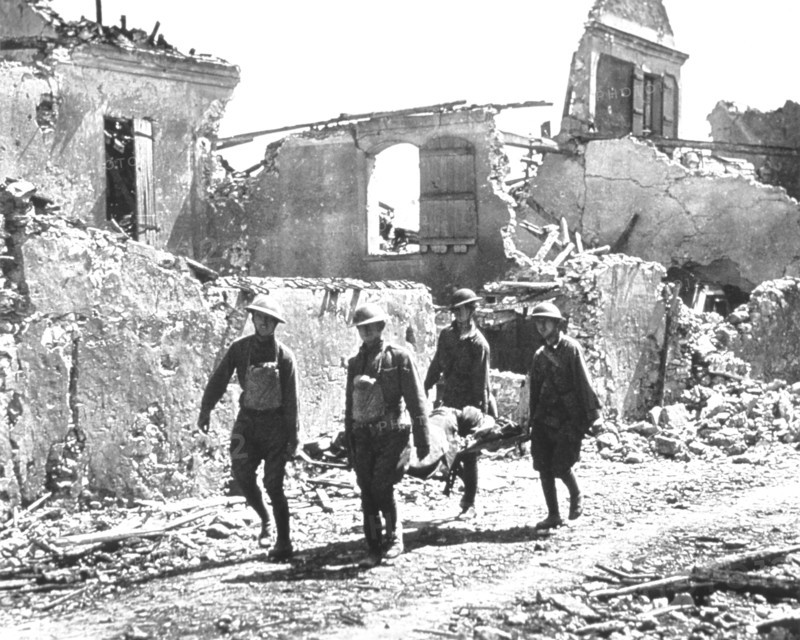 Four Soldiers carrying Wounded Soldier on Stretcher past Bombed-out Building, Vaux, 1918