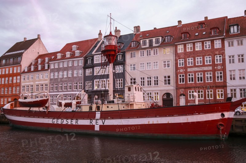 Boat on Nyhavn Canal with Quaint Buildings in Background at Sunset, Copenhagen,