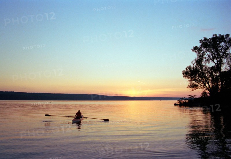 Silhouette of Man rowing Boat on Lake at Sunset,,