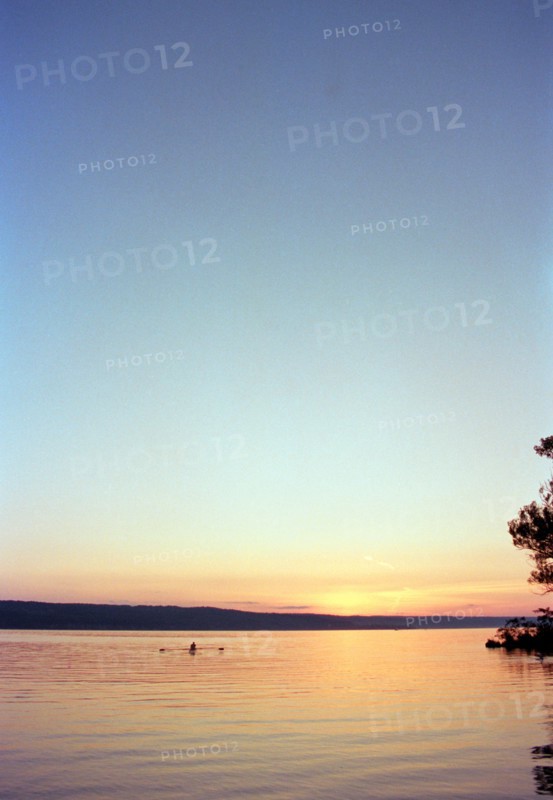 Silhouette of Man rowing Boat on Lake at Sunset,,