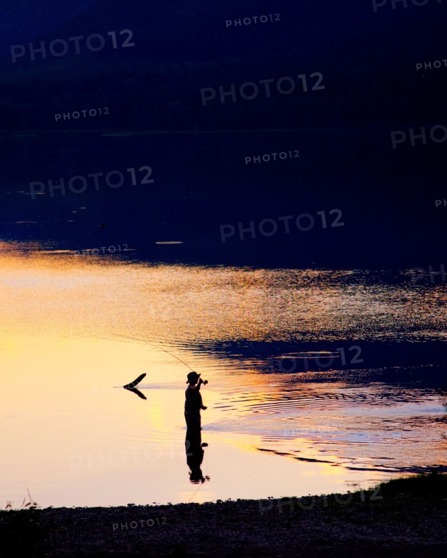 Silhouette of Man Fly-fishing in Lake,,