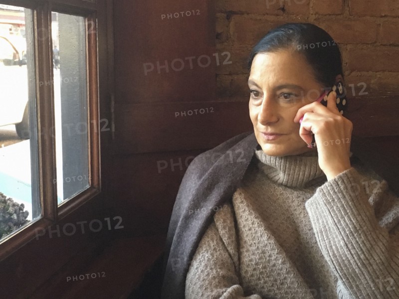 Mid-Adult Woman talking on Cell Phone in Restaurant,,