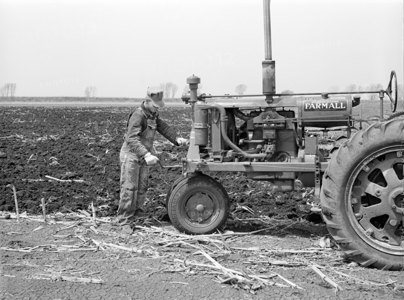 Farmer cranking Tractor while planting Corn, Listing method