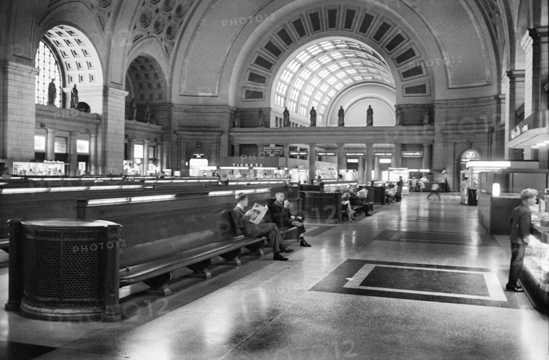 Passengers seated in long benches in the waiting room of Union Station, Washington