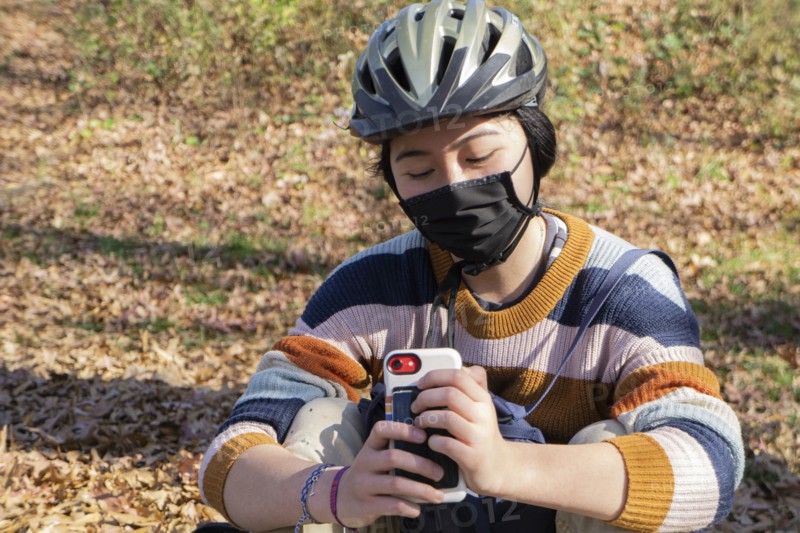 Teen Girl with Protective Mask Texting,