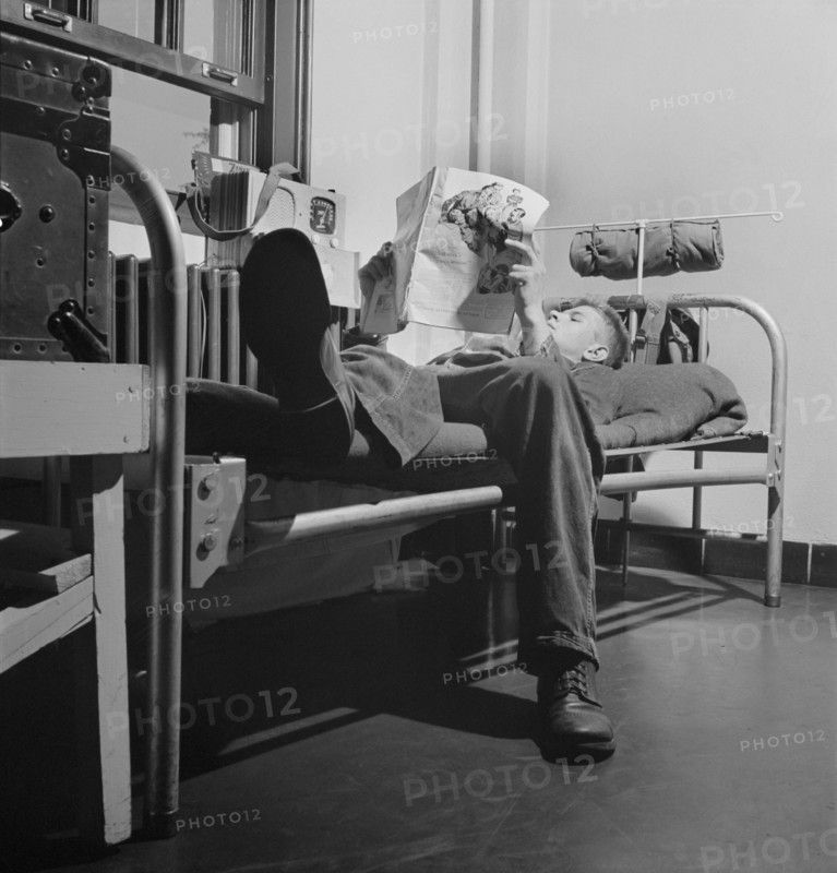Sergeant George Camblair reading an article in a magazine while relaxing after dinner