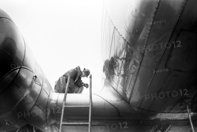 Mechanic Checking Fuel in Airplane on Rainy Day