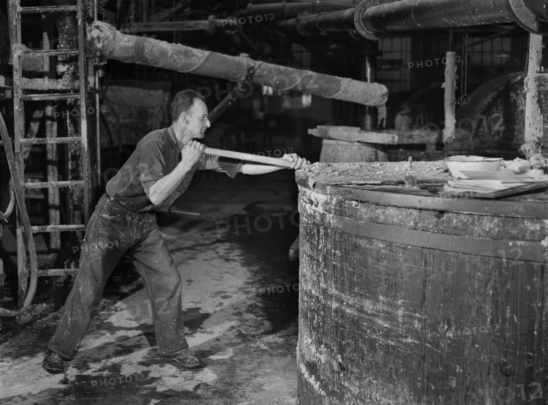 Worker stirring Paper Pulp in Large Vat