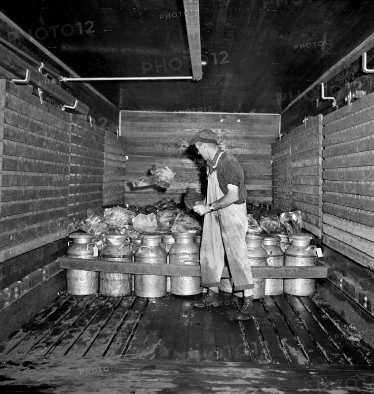 Worker shoveling Ice into Railroad Carload of Milk