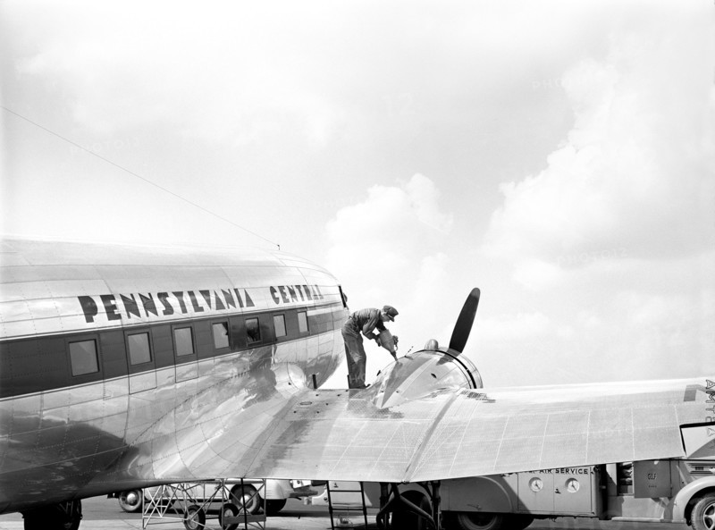 Mechanic adding Oil for the Airplane Engine prior to Takeoff