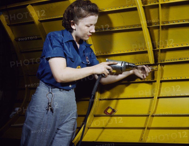 Woman operating hand drill on "Vengeance" dive bomber