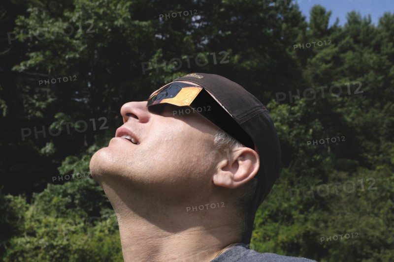 Mid-Adult Man wearing Eclipse Glasses while viewing Partial Solar Eclipse