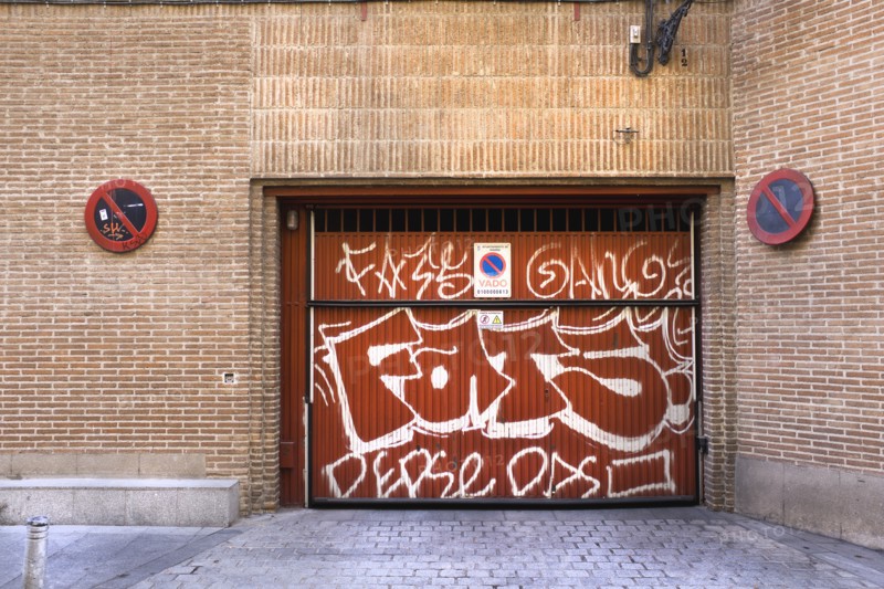 No parking sign at loading dock painted with graffiti