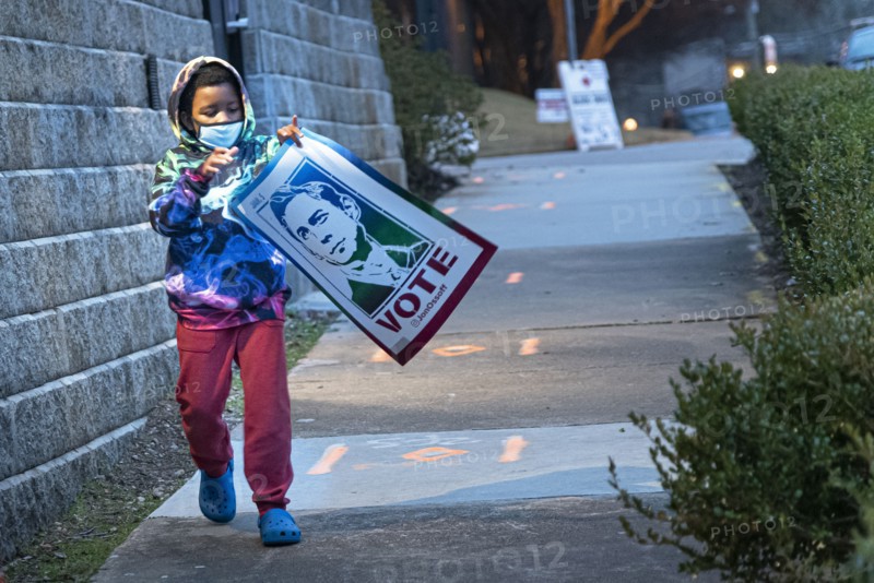 Young Boy carrying Congressman John Ossoff Banner after Campaign Rally