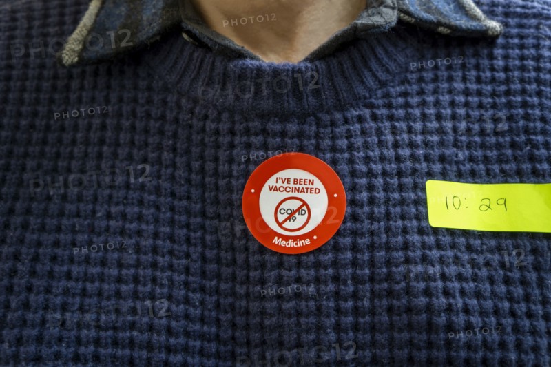 Man with COVID-19 Vaccination Sticker on Sweater