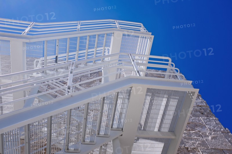 Low Angle View of White Fire Escape against Blue Sky