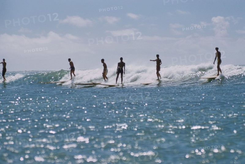 Silhouette of Surfers riding a Wave