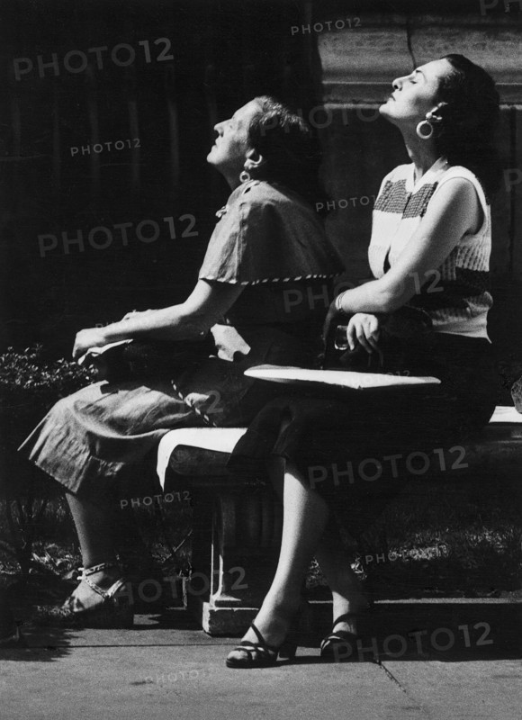Two Women sitting with their Heads tilted towards Sun