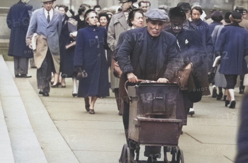 Man pushing Cart of Roasted Chestnuts on Sidewalk