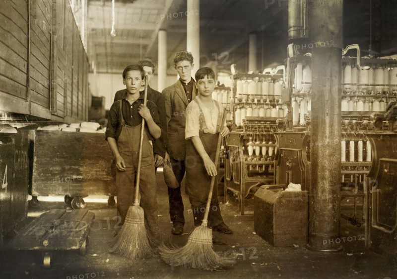 Young sweepers in spinning room of textile mill