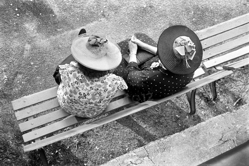Women wearing print dresses and large straw hats