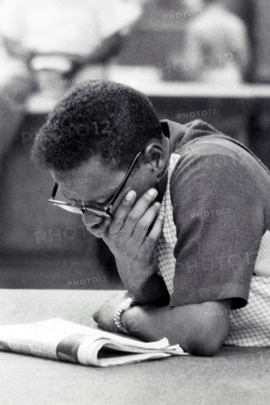 Half-length portrait of man reading newspaper