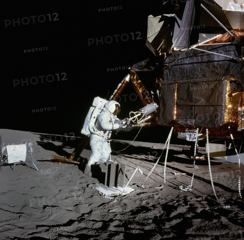 American astronaut Alan L. Bean using fuel transfer tool to remove fuel element from fuel cask mounted on lunar module during Apollo 12 extravehicular activity