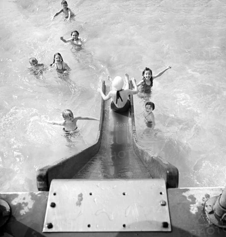 High angle view  of children entering swimming pool from water slide, Greenbelt, Maryland, USA, Marjory Collins, U.S. Office of War Information, June 1942