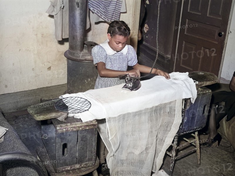 Young girl ironing, family is on governmetn relief, Chicago, Illinois, USA, Russell Lee, U.S. Farm Security Administration, April 1941