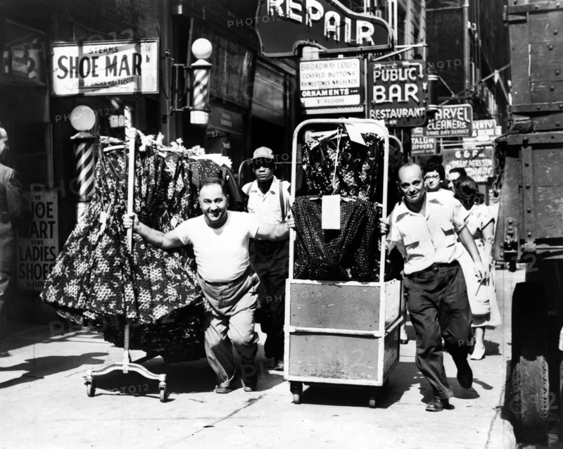 Men pulling racks of clothing on busy sidewalk in Garment District, New York City, New York, USA, Al Ravenna, New York World-Telegram and the Sun Newspaper Photograph Collection, 1955