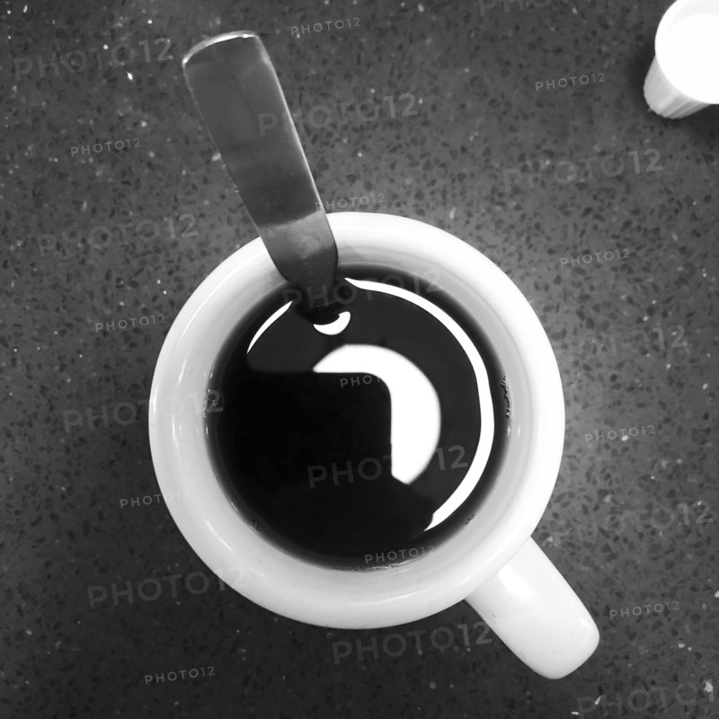 Cup of coffee and spoon, high angle view