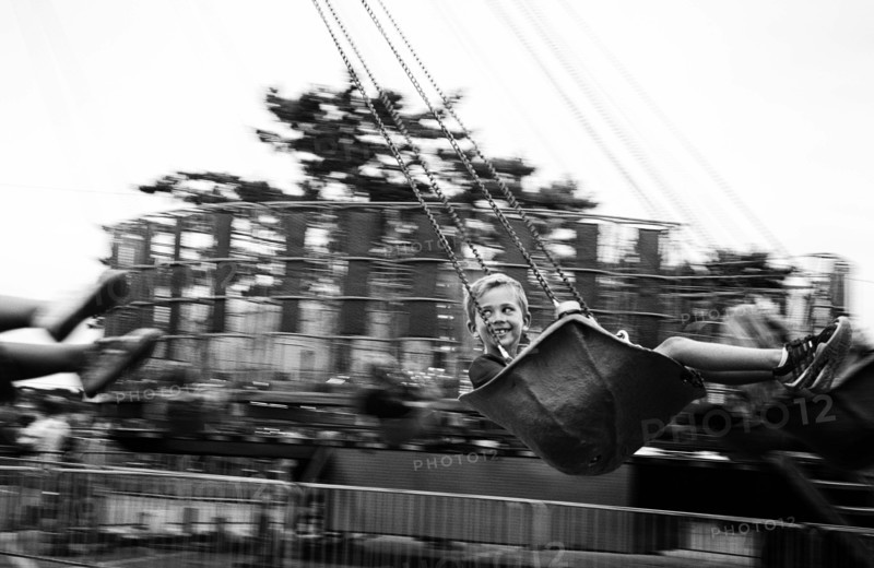 Smiling boy on swing ride at amusement park