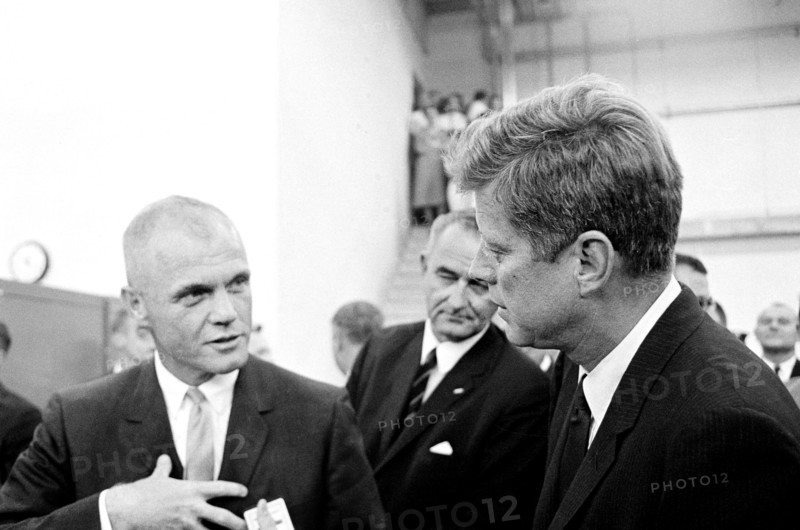U.S. President John F. Kennedy visiting with astronaut Lieutenant Colonel John H. Glenn, Jr. (left), during tour of spacecraft displays, U.S. Vice President Lyndon B. Johnson in background, Rich Building, Manned Spacecraft Center, Houston, Texas, USA, Cecil Stoughton, White House Photographs, September 12, 1962