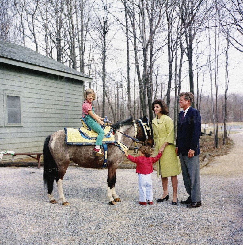 U.S. President John F. Kennedy and U.S. First Lady Jacqueline Kennedy stand with their children, Caroline Kennedy, sitting on her pony, "Macaroni", and John F. Kennedy, Jr., Camp David, Frederick County, Maryland, USA, Robert Knudsen, White House Photographs, March 31, 1963