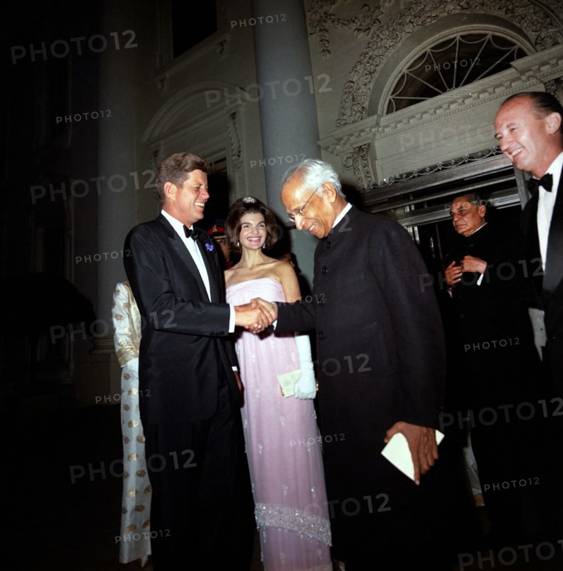President of India, Dr. Sarvepalli Radhakrishnan, shaking hands with U.S. President John F. Kennedy as U.S. First Lady Jacqueline Kennedy looks on following state dinner in his honor, North Portico, White House, Washington, D.C., USA, Cecil Stoughton, White House Photographs, June 3, 1963