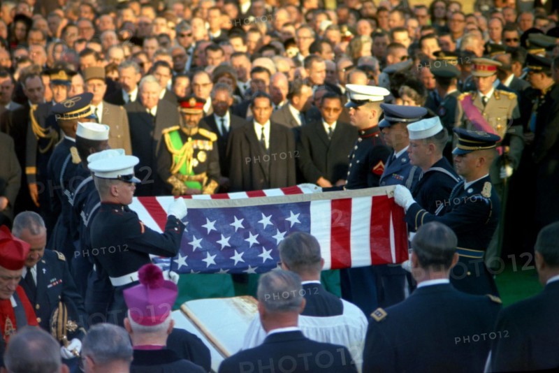 Officials and foreign dignitaries look on as honor guard pallbearers fold the casket flag during graveside services in the state funeral of President John F. Kennedy, Arlington National Cemetery, Arlington, Virginia, USA, Cecil Stoughton, White House Photographs, November 25, 1963
