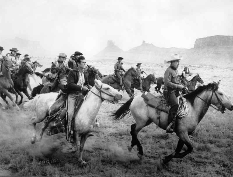 Stuart Whitman (foreground, left), Bruce Cabot (foreground, right), on-set of the western film, "The Comancheros", 20th Century-Fox, 1961