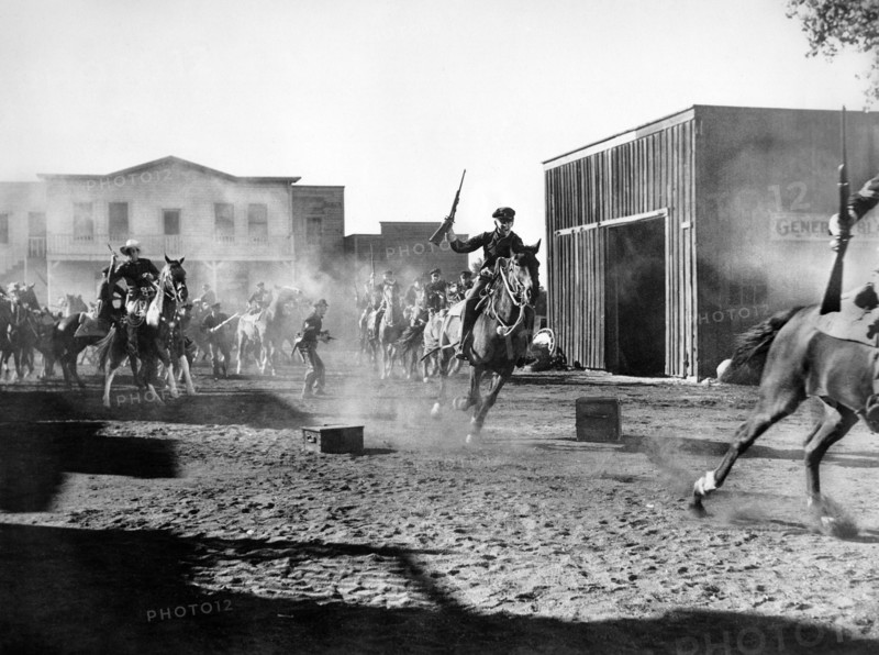 Bill Elliott (on horse, left), on-set of the western film, "Frontiers of '49", Columbia Pictures, 1939