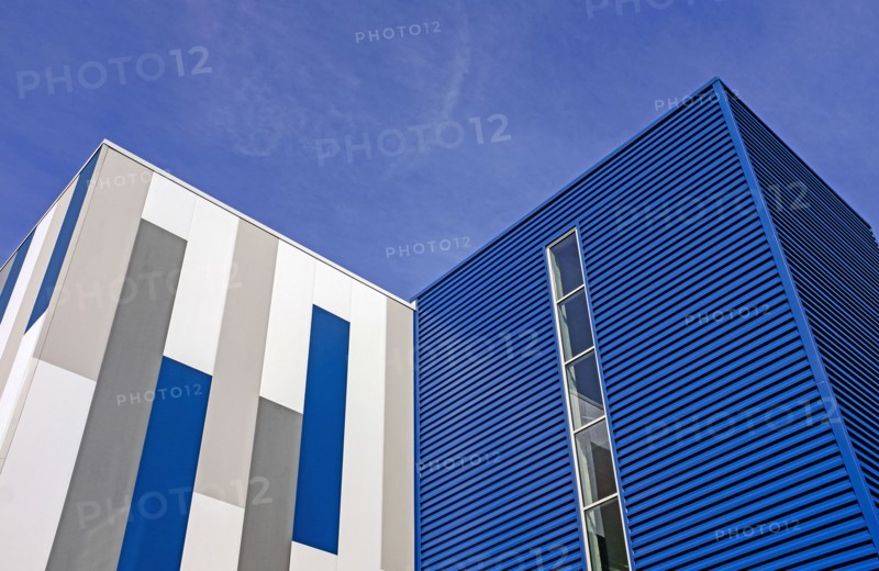 Low angle view of geometric building exterior, against blue sky