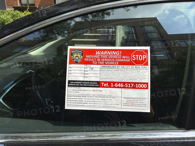 Wheel clamp device warning sign on car window