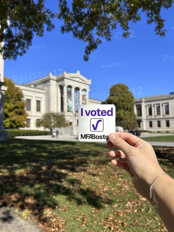 Hand holding "I Voted MFA Boston" sticker, Museum of Fine Arts, Boston, Massachusetts, USA
