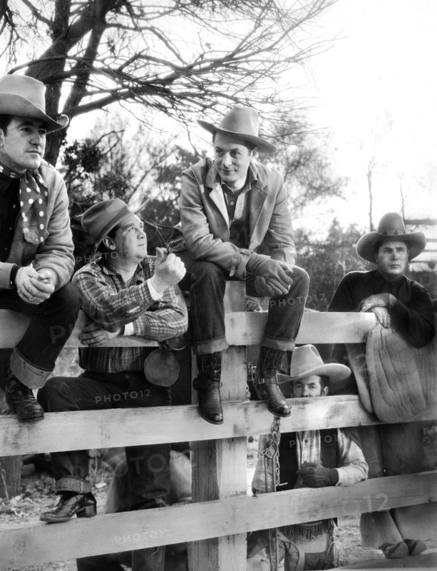 Robert Montgomery (center, sitting on fence), on-set of the western film, "Lovers Courageous", MGM, Loew's Inc., 1932