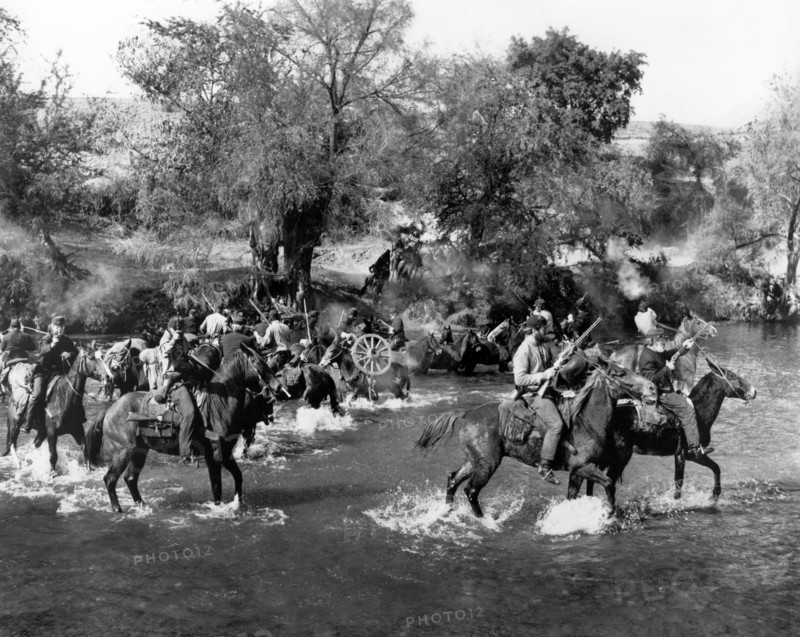 Union soldiers on horseback crossing river, on-set of the western film, "Major Dundee", Columbia Pictures, 1965