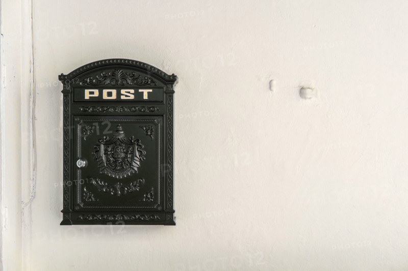 Black metal mailbox on white wall